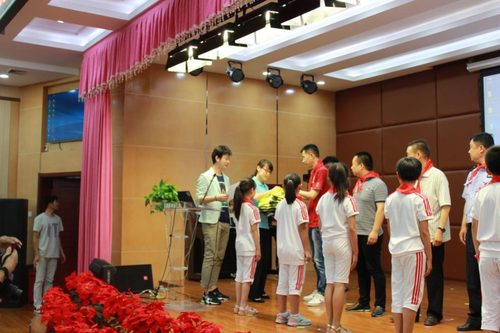 志愿者为孩子们演示如何正确佩戴安全背心 志愿者为孩子们演示如何正确佩戴安全背心